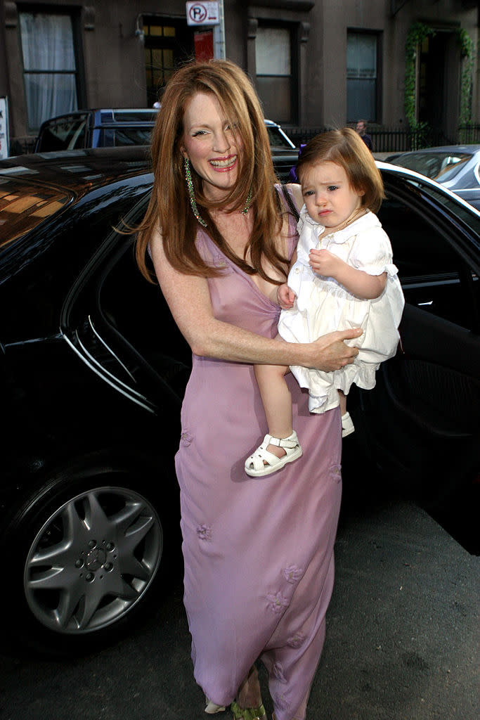 she's holding her daughter as she arrives to the wedding