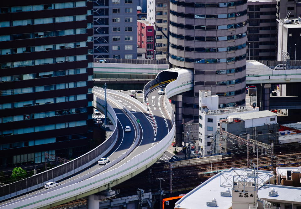 Ein Anblick, bei dem man zweimal hinschauen muss: Durch dieses japanische Hochhaus führt eine Autobahnauffahrt. (Bild: Yuri Smityuk\TASS via Getty Images)