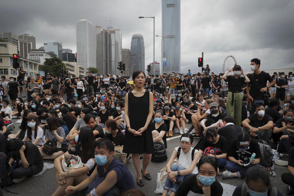 A protester, center, calls Hong Kong Chief Executive Carrie Lam to step down as she and others continue protest against the unpopular extradition bill near the Legislative Council in Hong Kong, Monday, June 17, 2019. A member of Hong Kong's Executive Council says the city's leader plans to apologize again over her handling of a highly unpopular extradition bill. (AP Photo/Kin Cheung)