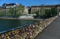 This April 9, 2014 photo shows love locks fixed on the Pont des Arts in Paris. A recent fad among travelers of hitching padlocks on bridges and at tourist attractions worldwide to symbolically immortalize their amorous attraction has swept up this reputed City of Love more than most. Now, two American-born women who live in Paris say they've had enough, launching a petition drive to try to get mostly laissez-faire city officials to step in and do something about what they call an unbearable eyesore in a majestic municipality. (AP Photo/Thibault Camus)