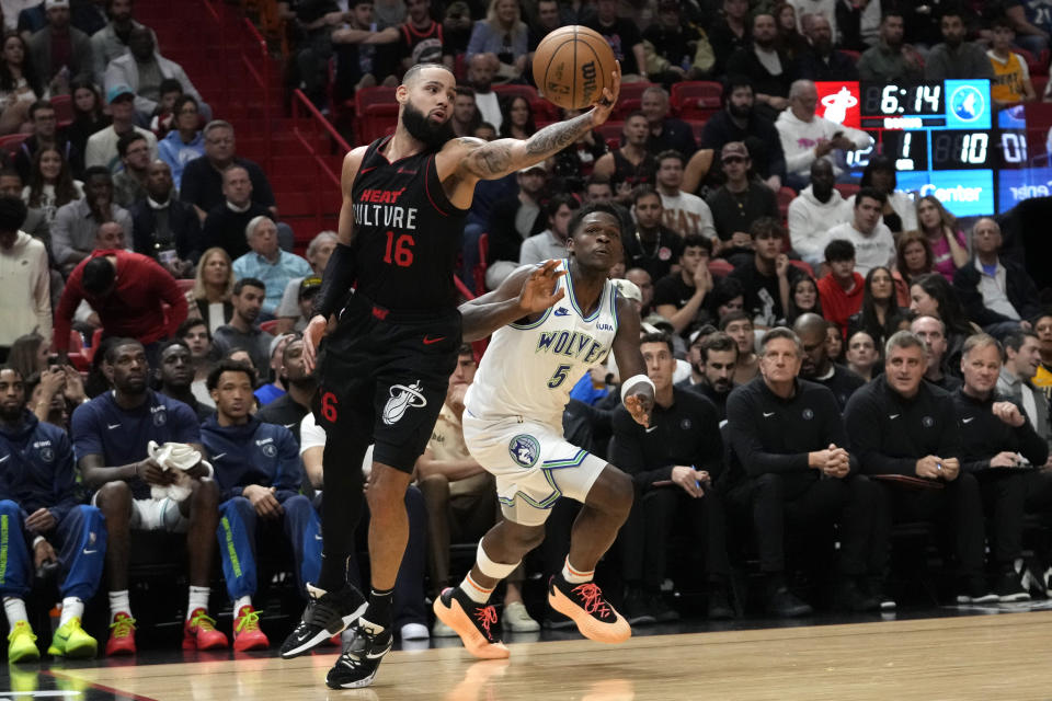 Miami Heat forward Caleb Martin (16) grabs a ball in front of Minnesota Timberwolves guard Anthony Edwards (5) during the first half of an NBA basketball game, Monday, Dec. 18, 2023, in Miami. (AP Photo/Lynne Sladky)