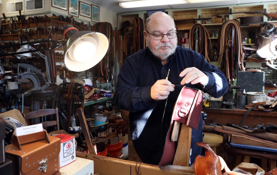 Dennis Knight, owner of River Ridge Leather Company in Roscoe Village, works on a bag in his shop.