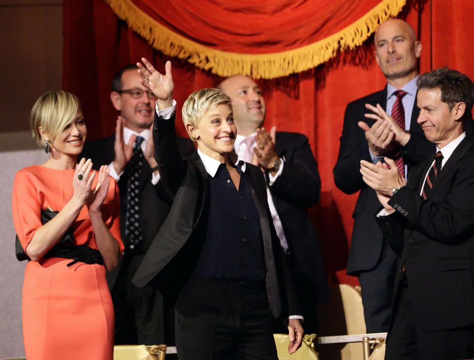 Entertainer Ellen DeGeneres, second from front left, waves as she is introduced, with wife Portia de Rossi, left, before DeGeneres receives the 15th annual Mark Twain Prize for American Humor at the Kennedy Center, Monday, Oct. 22, 2012, in Washington. (AP Photo/Alex Brandon)