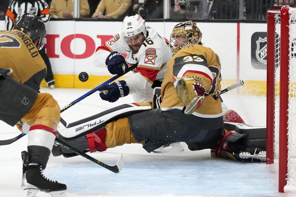 Florida Panthers center Aleksander Barkov, center, tries to get a shot past Vegas Golden Knights goaltender Adin Hill, right, as defenseman Alex Pietrangelo helps defend during the first period in Game 5 of the NHL hockey Stanley Cup Finals Tuesday, June 13, 2023, in Las Vegas. (AP Photo/John Locher)