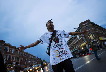 A demonstrator stands on the street at North Ave and Pennsylvania Ave in Baltimore, Maryland April 30, 2015. REUTERS/Eric Thayer