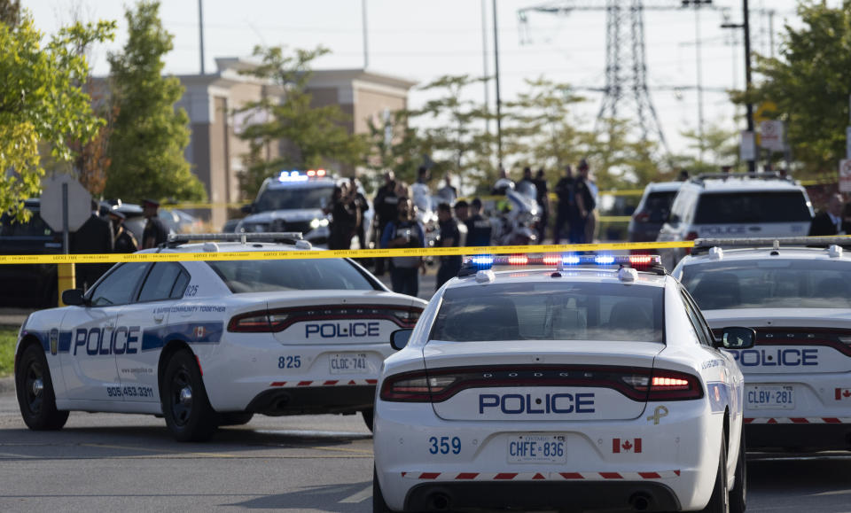 Police officers gather at the scene of a shooting in Mississauga, Ontario, Monday, Sept. 12, 2022. (Arlyn McAdorey/The Canadian Press via AP)