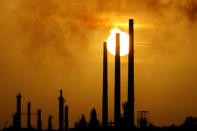 The sun is seen setting behind Isla refinery in Willemstad on the island of Curacao June 16, 2008. REUTERS/Jorge Silva/File Photo