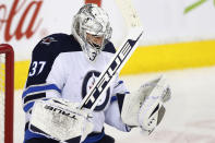 Winnipeg Jets goalie Connor Hellebuyck celebrates the team's 4-2 victory over the Calgary Flames in an NHL hockey game Saturday, Nov. 27, 2021, in Calgary, Alberta. (Larry MacDougal/The Canadian Press via AP)