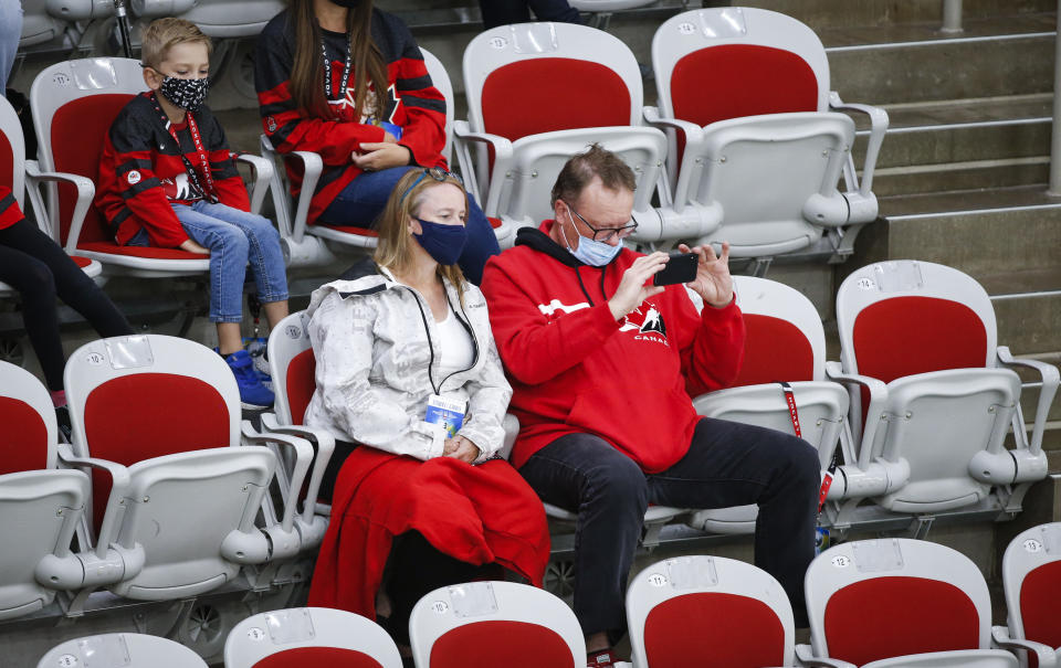 Family members watch the action during the second period of an IIHF women's hockey championship game between Canada and Finland in Calgary, Alberta, Friday, Aug. 20, 2021. (Jeff McIntosh/The Canadian Press via AP)