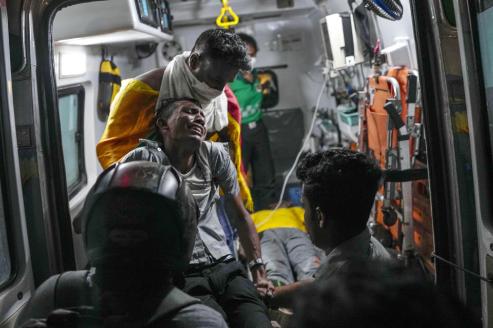 An injured protester reacts in pain as he is shifted to hospital in an ambulance during clashes with police near parliament in Colombo, Sri Lanka, Wednesday, July 13, 2022. Sri Lanka’s president fled the country without stepping down Wednesday, plunging a country already reeling from economic chaos into more political turmoil. Protesters demanding a change in leadership then trained their ire on the prime minister and stormed his office. (AP Photo/Rafiq Maqbool)