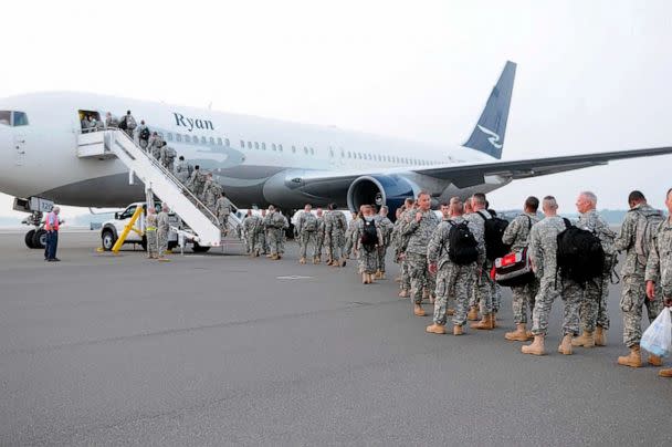 PHOTO: Members of the 218th Maneuver Enhancement Brigade wait on the Charleston tarmac before departing for annual training in 2010. (DOD/108th Public Affairs Detachment)