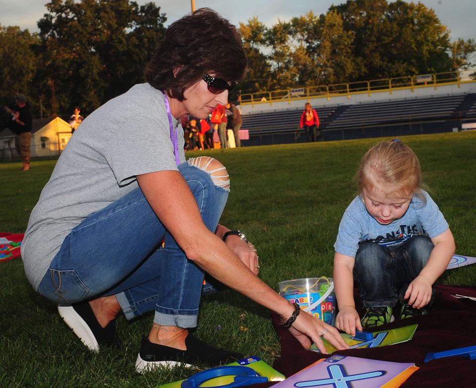 Amy Blickensderfer, aka Mrs. B, a teacher at B.L. Miller Elementary School in Sebring, helps Rowan Riggs, 3, with recognizing letters of the alphabet during the Literacy Under the Lights event Saturday, Sept. 16, 2023 at Schaefer-Davies Stadium in Sebring.