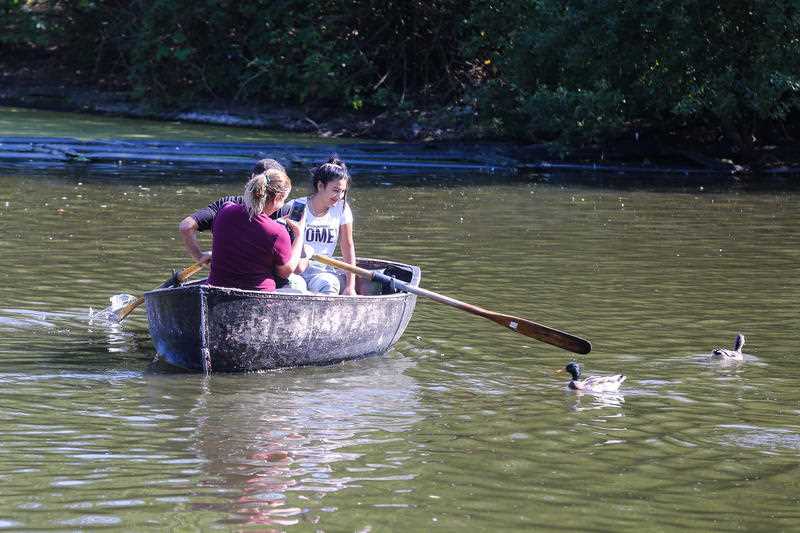 People enjoy a boat ride in Finsbury Park boating lake, north London on a warm and sunny afternoon as mini heatwave hits the city.