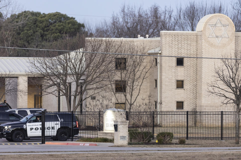 Police stand in front of the Congregation Beth Israel synagogue, Sunday, Jan. 16, 2022, in Colleyville, Texas. A man held hostages for more than 10 hours Saturday inside the temple. The hostages were able to escape and the hostage taker was killed. FBI Special Agent in Charge Matt DeSarno said a team would investigate "the shooting incident." (AP Photo/Brandon Wade)