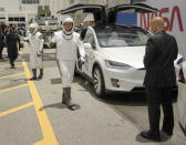 In this photo provided by NASA, astronauts Douglas Hurley, left, and Robert Behnken wave as they leave the Neil A. Armstrong Operations and Checkout Building on their way to Pad 39-A, at the Kennedy Space Center in Cape Canaveral, Fla., Wednesday, May 27, 2020. The two astronauts will fly on a SpaceX test flight to the International Space Station. For the first time in nearly a decade, astronauts will blast into orbit aboard an American rocket from American soil, a first for a private company. (Bill Ingalls/NASA via AP)