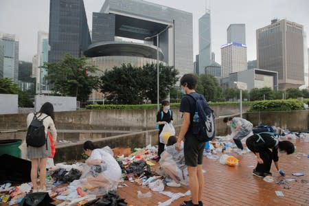 People clear rubbish outside the Legislative Council building after violent clashes in Hong Kong