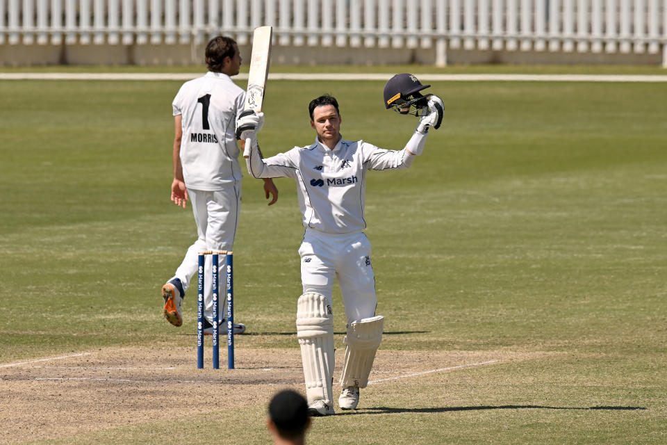 Peter Handscomb (pictured) raises his bat in celebration.