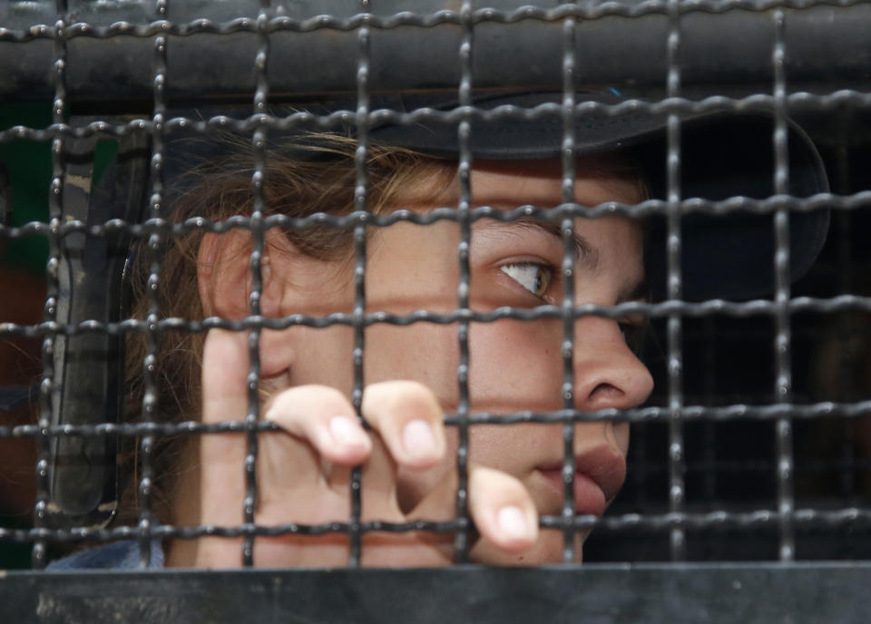 Belarusian model Anastasia Vashukevich sits in a van leaving the Immigration Detention Center for an airport for deportation in Bangkok, Thailand, Thursday, Jan. 17, 2019. Thai officials say they are deporting Vashukevich who claimed last year that she had evidence of Russian involvement in helping elect Donald Trump president. (AP Photo/Sakchai Lalit)