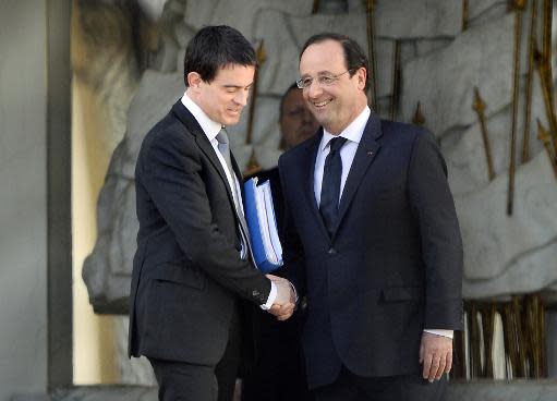 El presidente francés, François Hollande (dcha), estrecha la mano de su nuevo primer ministro, Manuel Valls, tras reunirse en el Palacio del Elíseo, en París, el 2 de abril de 2014 (AFP | Eric Feferberg)