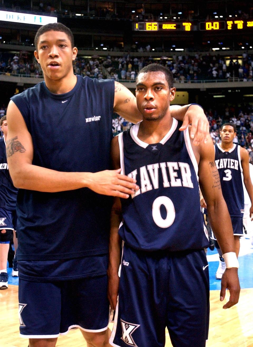 2004.0328.10.1--XAV VS DUKE--Xavier's Will Caudle hugs Lionel Chalmers (0) after they were defeated 66-63 by Duke at the Atlanta Regional Final 2004 NCAA Men's Basketball Championship Sunday, March 28, 2004. Photo by Craig Ruttle/Cincinnati Enquirer