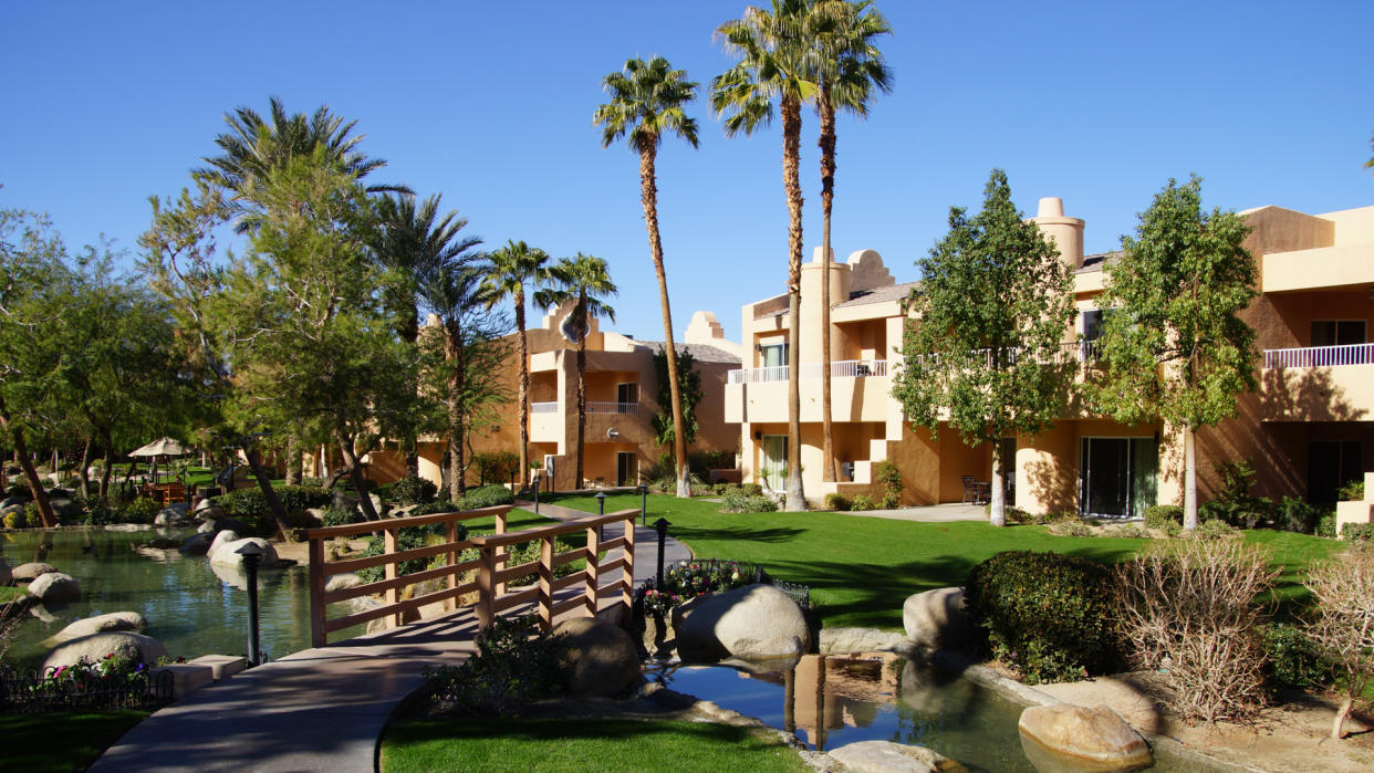 RANCHO MIRAGE, CALIFORNIA - DEC 16, 2015 - Southwestern style hotel buildings with ponds in green oasis with Palm trees, Rancho Mirage, California - Image.