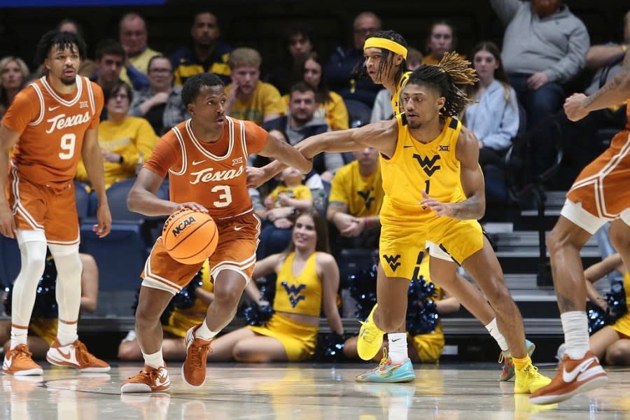 Texas guard Max Abmas (3) is defended by West Virginia guard Noah Farrakhan (1) during the second half of an NCAA college basketball game on Saturday, Jan. 13, 2024, in Morgantown, W.Va. (AP Photo/Kathleen Batten)