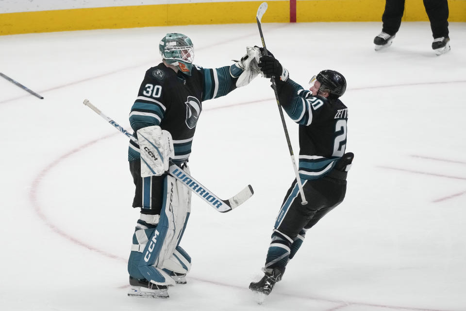 San Jose Sharks goaltender Magnus Chrona (30) celebrates with left wing Fabian Zetterlund (20) after the Sharks defeated the Ottawa Senators in an NHL hockey game in San Jose, Calif., Saturday, March 9, 2024. (AP Photo/Jeff Chiu)