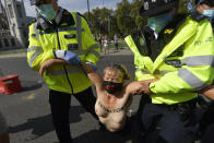 NOTE NUDITY Police detain a topless Extinction Rebellion protester outside the Houses of Parliament, London, on the last day of demonstrations.