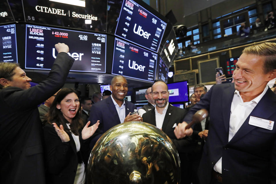 FILE - In this Friday, May 10, 2019 file photo, Uber board member Ryan Graves, right, rings a ceremonial bell as the company's stock opens for trading during its initial public offering at the New York Stock Exchange. Stacey Cunningham, second from left, president of the NYSE, Tony West, center, Uber's Chief Legal Officer, and CEO Dara Khosrowshahi, second from right, applaud. A fare war between Uber and Lyft has led to billions of dollars in losses for both ride-hailing companies as they fight for passengers and drivers. But in one way it has been good for investors who snatched up the newly public companies' stock: The losses have scared off the competition, giving the leaders a duopoly in almost every American city. (AP Photo/Richard Drew)