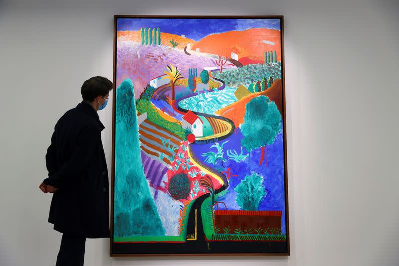 An employee looks at a painting by David Hockney entitled 'Nichols Canyon' which has an estimated value of $35 million at Phillips auction house in London