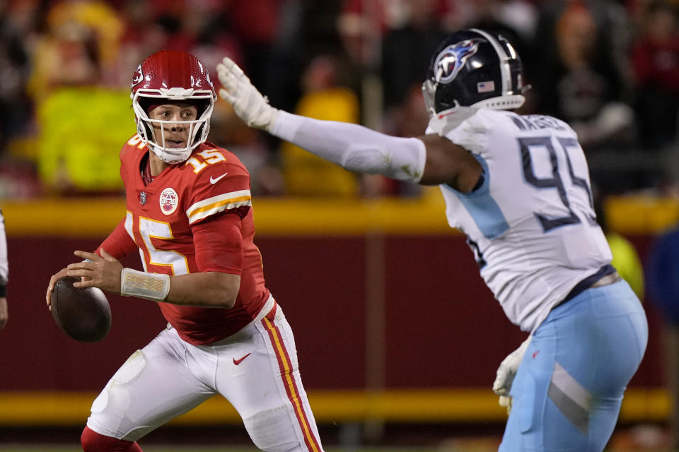 Kansas City Chiefs quarterback Patrick Mahomes (15) scrambles as Tennessee Titans defensive end DeMarcus Walker (95) defends during overtime of an NFL football game Sunday, Nov. 6, 2022, in Kansas City, Mo. The Chiefs won 20-17. (AP Photo/Charlie Riedel)