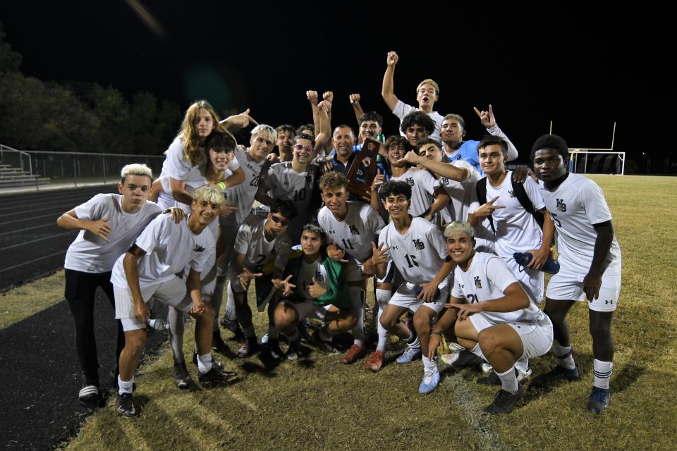 The West Boca boys soccer team poses for a celebratory photo with the district title trophy following their 3-2 win over Dwyer in the finals (Jan. 31, 2023).