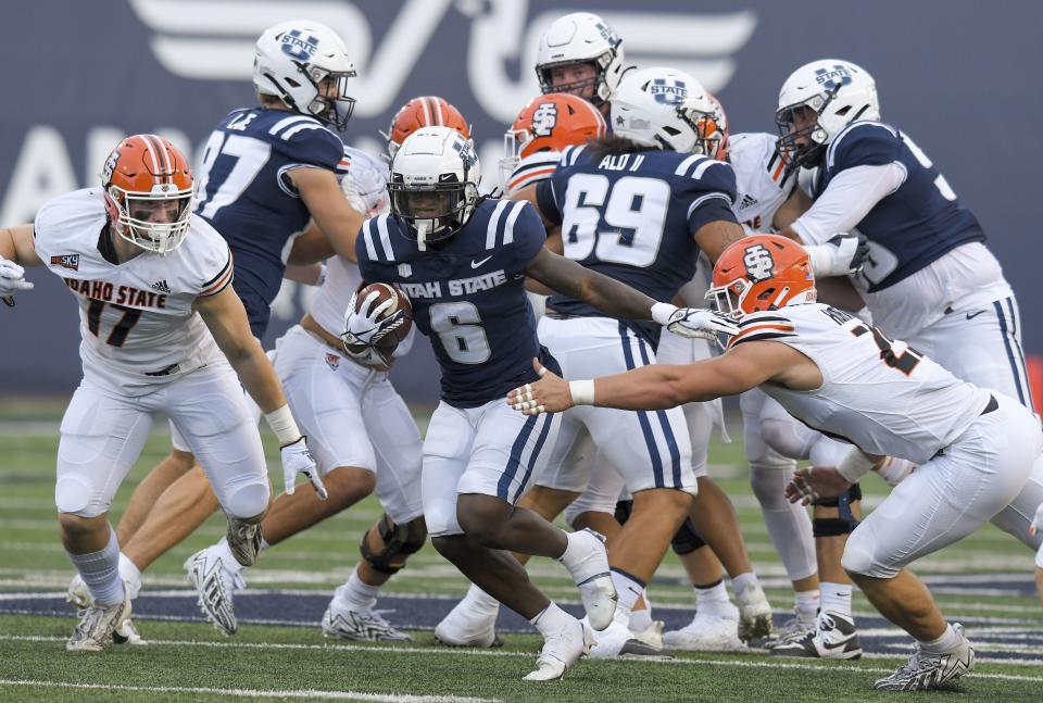 Utah State running back Davon Booth (6) carries the ball for a touchdown as Idaho State linebacker Nathan Reynolds (17) and Idaho State defensive lineman Cortland Horton (29) defend during the first half of an NCAA college football game Saturday, Sept. 9, 2023, in Logan, Utah. | Eli Lucero/The Herald Journal via AP
