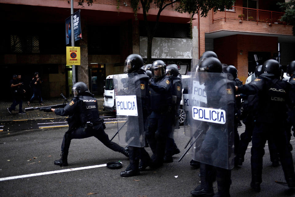 People protest as police try to control the area at a polling station in the referendum vote.