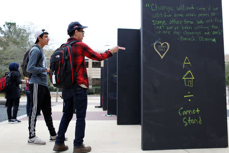 People write on a message wall during the "Aggies United" official school event outside Kyle Field at Texas A&M University, before a separate event not sanctioned by the school on campus where white nationalist leader Richard Spencer of the National Policy Institute is due to speak, in College Station, Texas, U.S. December 6, 2016. REUTERS/Spencer Selvidge