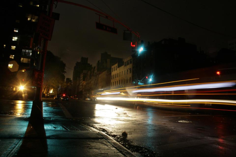 Cars pass through a darkened neighborhood on the west side of Manhattan on Monday, Oct. 29, 2012 in New York. Much of New York was plunged into darkness Monday by a superstorm that overflowed the city's historic waterfront, flooded the financial district and subway tunnels and cut power to hundreds of thousands of people. (AP Photo/Peter Morgan)