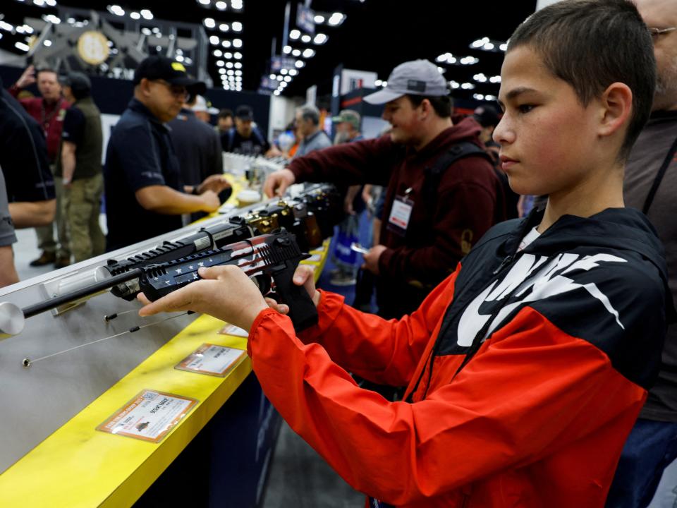 A 14-year-old from Oklahoma holds a machine gun.