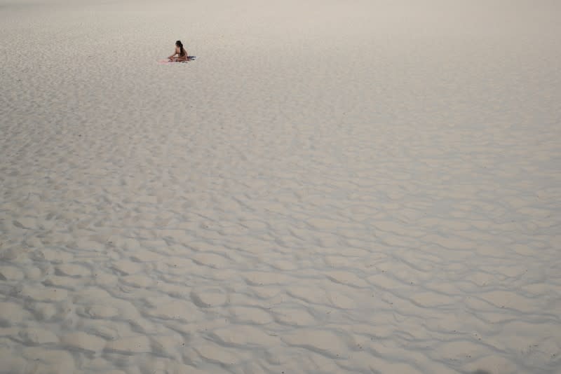 A single sunbather remains following the closure of Bondi Beach to prevent the spread of the coronavirus disease (COVID-19) in Sydney