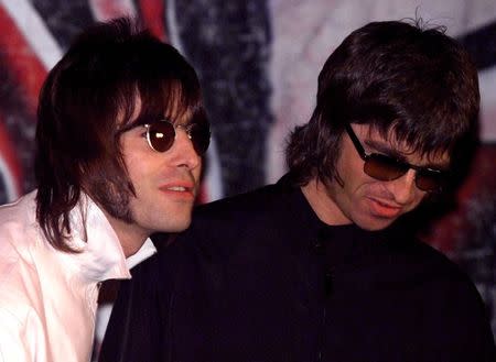 FILE PHOTO: Liam and Noel (R) Gallagher, of the British rock band Oasis, wait for the start of a news conference at a pub in London, Britain August 25. REUTERS/Dylan Martinez/File Photo