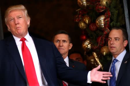Incoming White House Chief of Staff Reince Priebus (R) and U.S. Army Lieutenant General Michael Flynn (C) look at U.S. President-elect Donald Trump as he talks with the media at Mar-a-Lago estate where Trump attends meetings, in Palm Beach, Florida, U.S., December 21, 2016. REUTERS/Carlos Barria