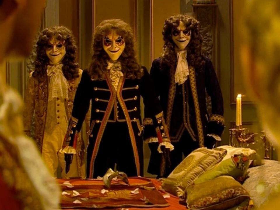 Three clockwork androids with creepy masks and wigs