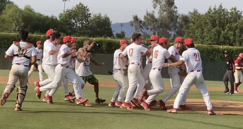 Harvard-Westlake players celebrate the pitching performance of freshman Bryce Rainer in 3-2 win over Orange Lutheran.