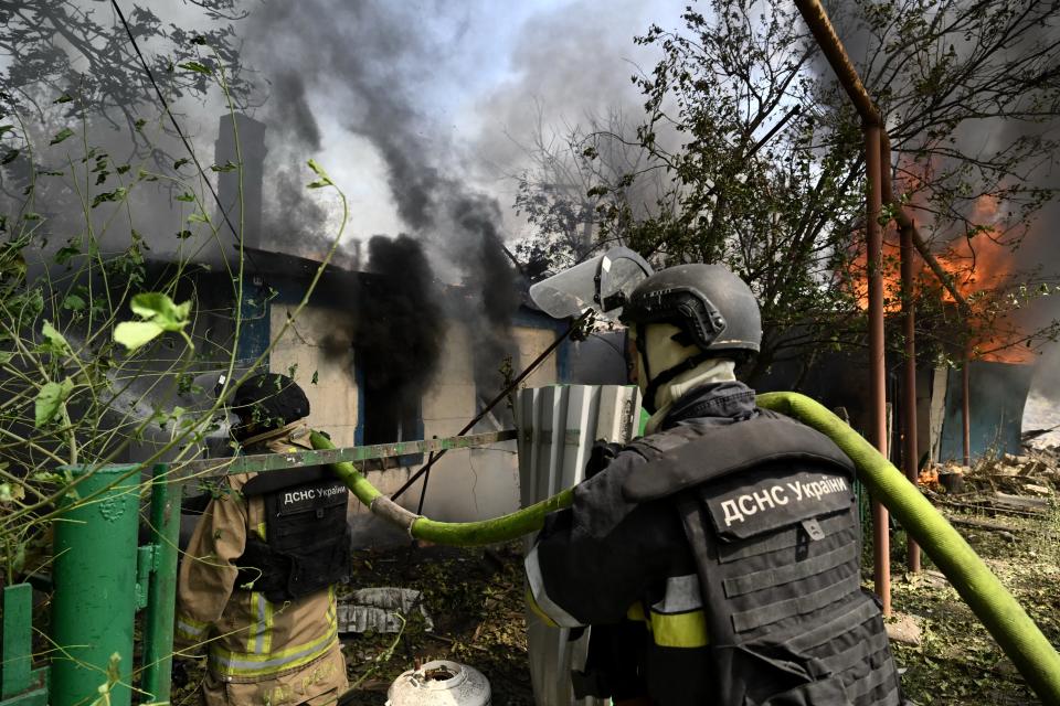 Ukrainian firefighters work to extinguish a fire in a private house that broke out a day after a missile attack in Myrnograd, Donetsk region (AFP via Getty Images)