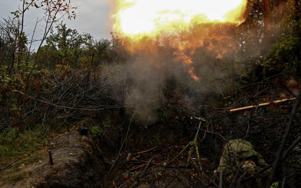 A Ukrainian serviceman fires a mortar toward Russian troops at a position in a front line