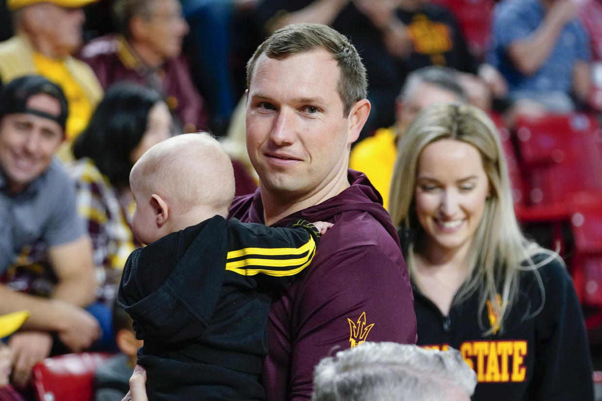 Arizona State's new football head coach Kenny Dillingham his son and wife Briana, right, attend the Sun Devils' NCAA college basketball game against Arizona, Saturday, Dec. 31, 2022, in Tempe, Ariz. (AP Photo/Darryl Webb)
