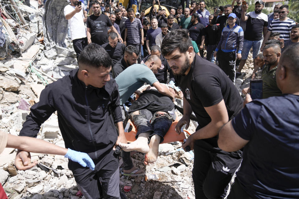 Palestinians remove the body of a dead man after a military operation in the Palestinians town of Deir al-Ghusun, near the West Bank town of Tulkarem, Saturday, May 4, 2024. (AP Photo/Majdi Mohammed)