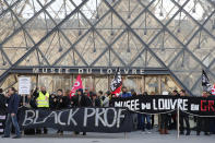 Striking employees hold banners outside the Louvre museum Friday, Jan. 17, 2020 in Paris. Paris' Louvre museum was closed Friday as dozens of protesters blocked the entrance to denounce the French government's plans to overhaul the pension system. (AP Photo/Francois Mori)