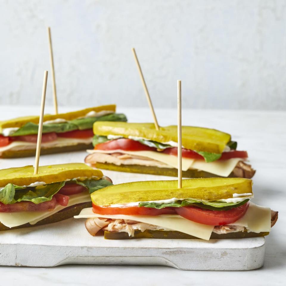 <p>Cut down on carbs by swapping out the bread for slices of pickle to make these fun turkey and Cheddar sandwiches. Roma tomatoes are the perfect oblong shape for these mini sandwiches but feel free to use regular tomatoes--simply cut the slices in half so they fit nicely on the pickle sandwich. These sandwiches are an easy lunch, but they're also great on a party tray for a casual get-together. <a href="https://www.eatingwell.com/recipe/276621/pickle-sub-sandwiches-with-turkey-cheddar/" rel="nofollow noopener" target="_blank" data-ylk="slk:View Recipe" class="link ">View Recipe</a></p>