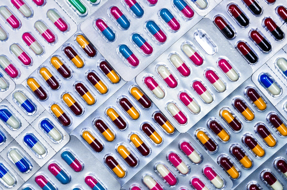 Full frame of colorful antimicrobial capsule pills. Quality control error in pharmaceutical manufacturing. Blister pack missing one capsule of antibiotic pill. Drug resistance. Defective concept.