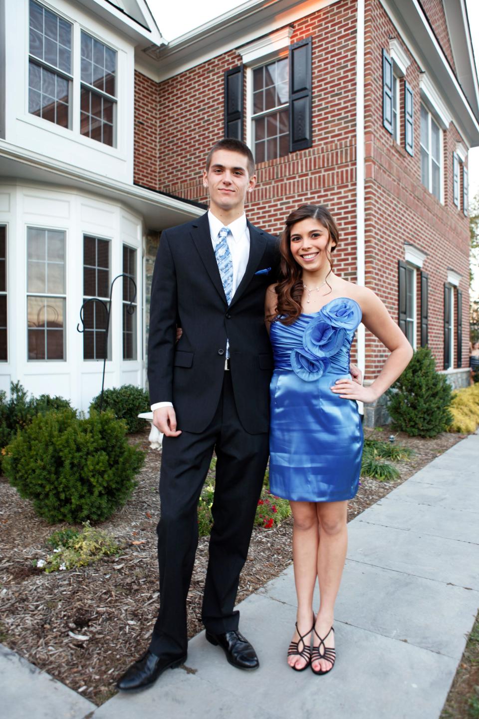 a couple posing for a prom photo